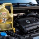 Butelka oleju Castrol Edge 5W-30 stojąca obok silnika Volkswagena TSI.