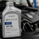 Butelka oleju Volkswagen LongLife III 0W-30 na tle silnika samochodowego