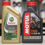 Butelki oleju silnikowego Castrol Power1 Racing i Motul 7100 4T 10W-50 na blacie warsztatowym