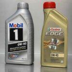 Butelki olejów silnikowych Mobil 1 i Castrol Edge 0W-40 stojące obok siebie na metalowej powierzchni