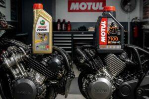 Dwa silniki motocyklowe z butelkami olejów Castrol Power1 i Motul 7100 w warsztacie