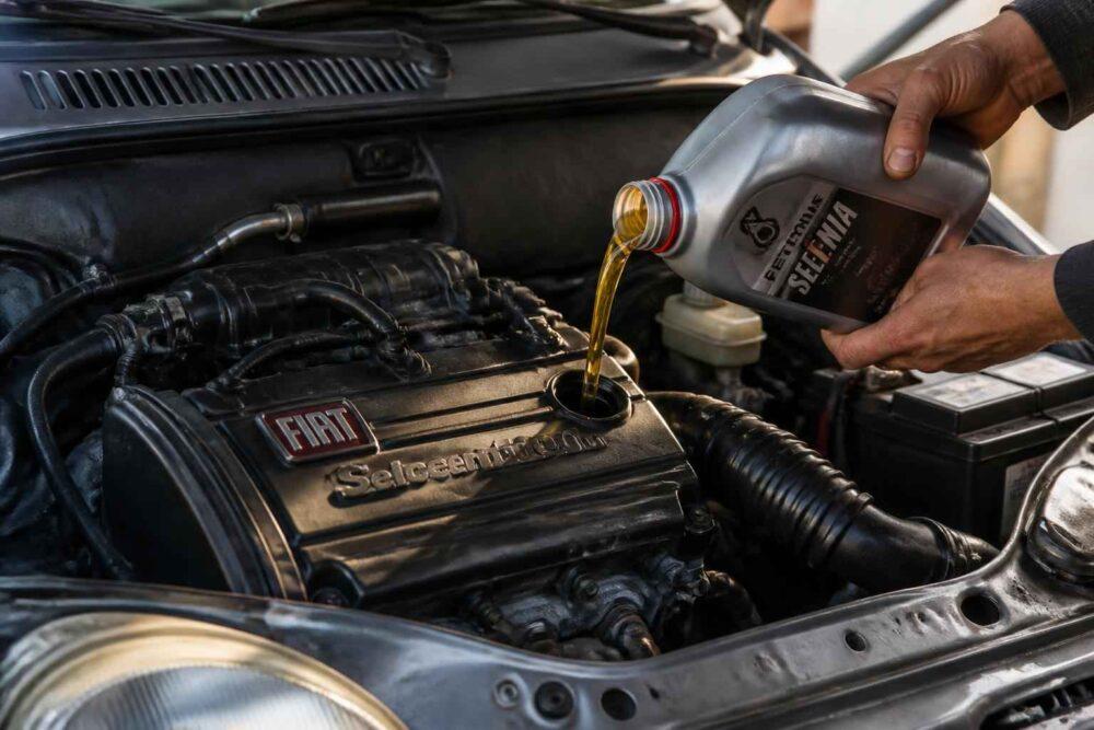 Mechanik wlewa olej Shell do silnika samochodu Fiat