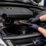 Mechanik spuszcza olej z silnika samochodu Ford do pojemnika serwisowego